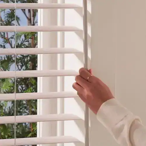 Hand using the EasyTilt bar to tilt Hunter Douglas Aria fabric blind vanes
