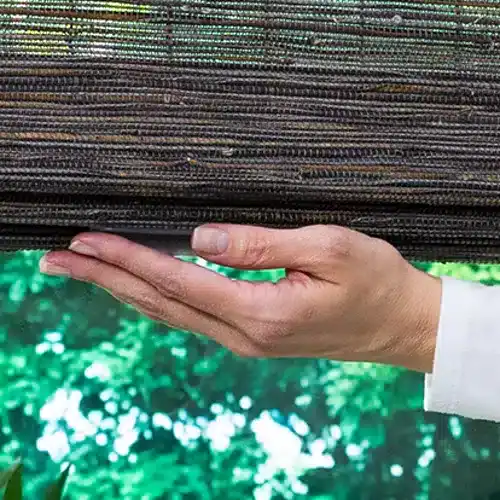 Hand lowering Hunter Douglas Provenance woven wood shades with the cordless LiteRise system