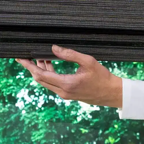 Hand lowering Hunter Douglas Alustra Woven Textures Roman Shades with cordless LiteRise