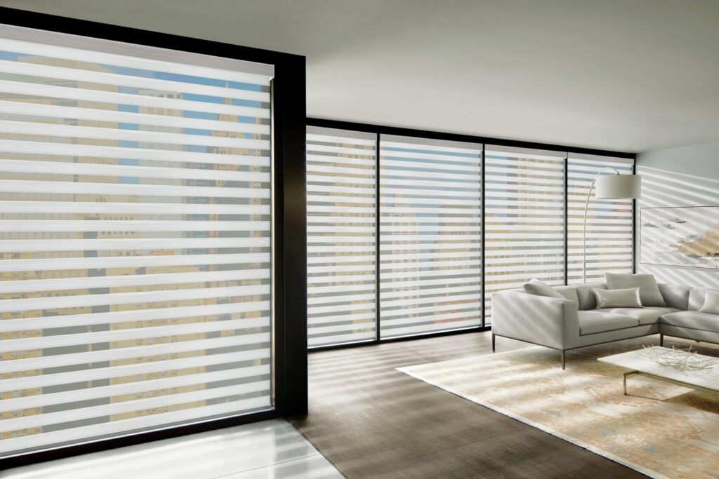 Designer Banded Shades in Buckingham on a wall of large windows in a living room