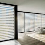 Designer Banded Shades in Buckingham on a wall of large windows in a living room