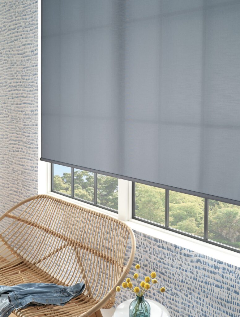 Close-up of Designer Roller Shades in Urban Loft Hues with a cordless lift beside a rattan chair