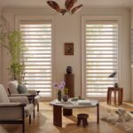 Alustra® Pirouette® Window Shadings in Oakley Sand Jasper with PowerView® Automation in a living room with a dog